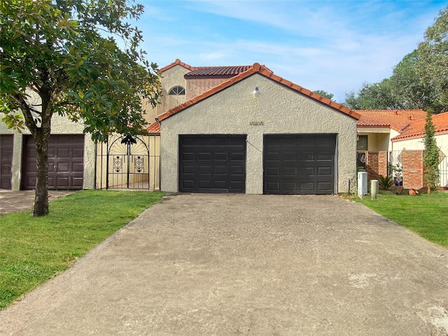 mediterranean / spanish house with a tile roof, driveway, an attached garage, and stucco siding