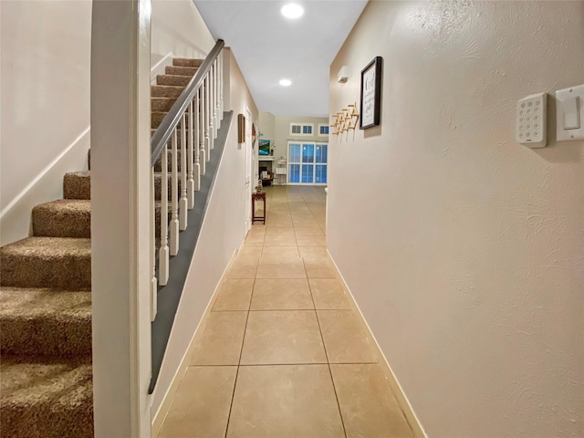 hall with light tile patterned floors, recessed lighting, visible vents, stairway, and baseboards