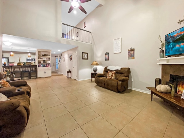 living area with a tile fireplace, stairway, baseboards, and light tile patterned floors