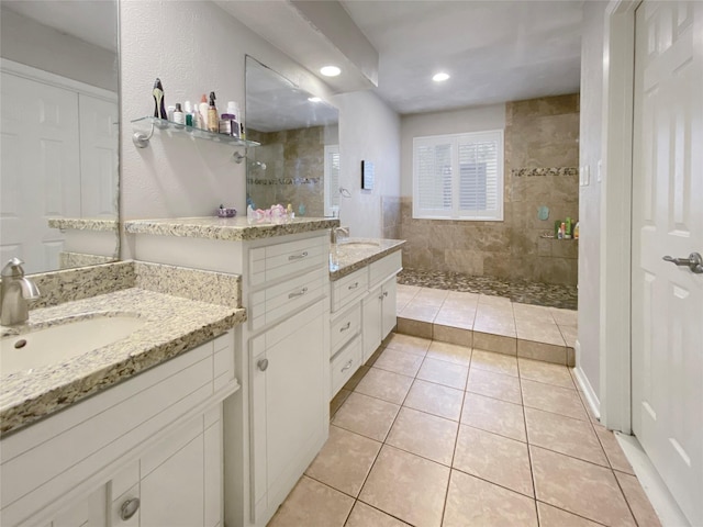 full bathroom with two vanities, a walk in shower, a sink, and tile patterned floors