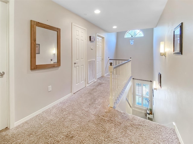 hallway featuring recessed lighting, carpet flooring, visible vents, an upstairs landing, and baseboards