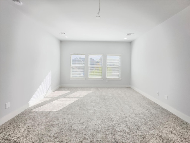 carpeted empty room with visible vents and baseboards