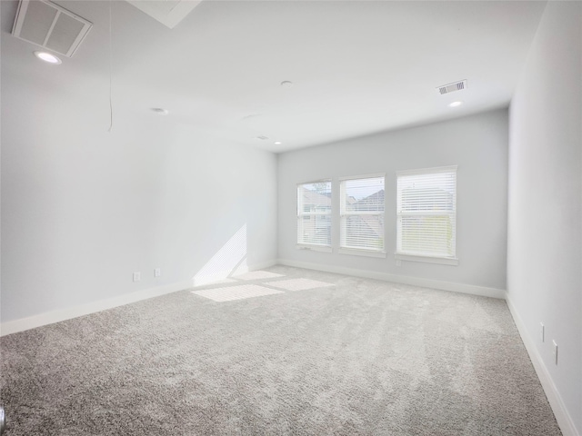 carpeted empty room featuring baseboards, recessed lighting, visible vents, and attic access