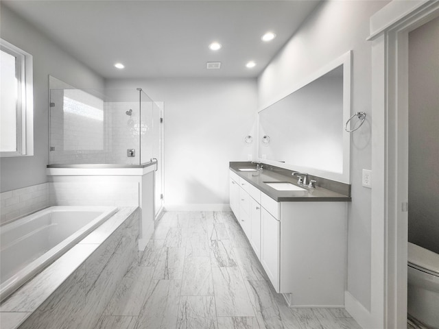 full bathroom featuring a stall shower, a garden tub, a sink, and toilet