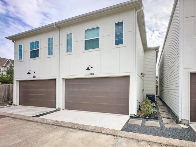 view of front of property featuring a garage and central air condition unit