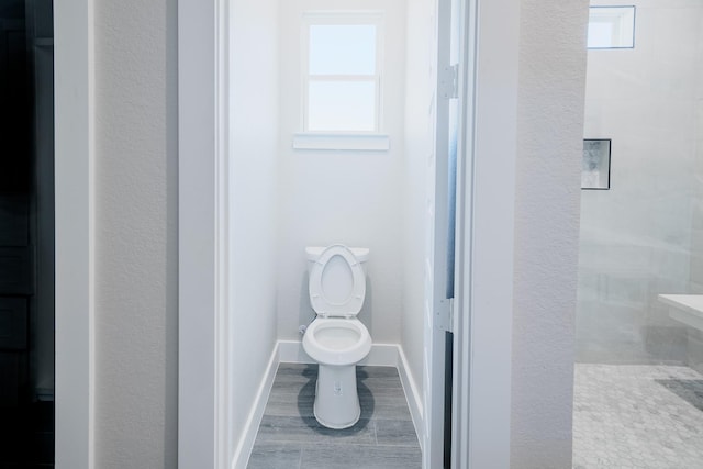 bathroom featuring toilet and baseboards