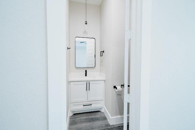 bathroom with vanity, baseboards, and wood finished floors