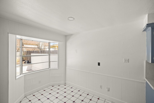 empty room with light floors and wainscoting