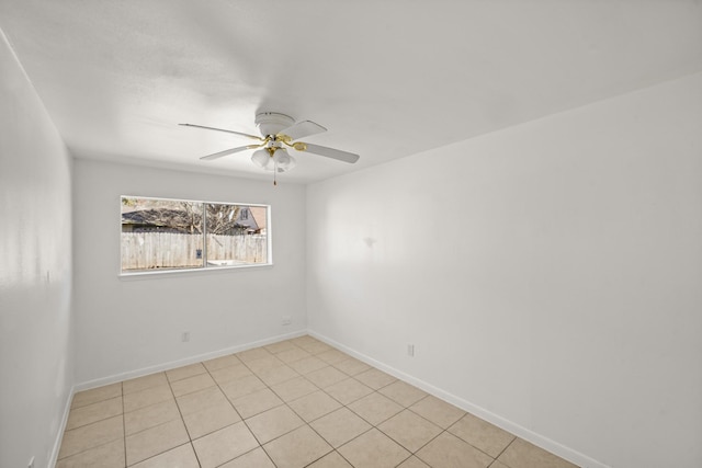 spare room with a ceiling fan and baseboards