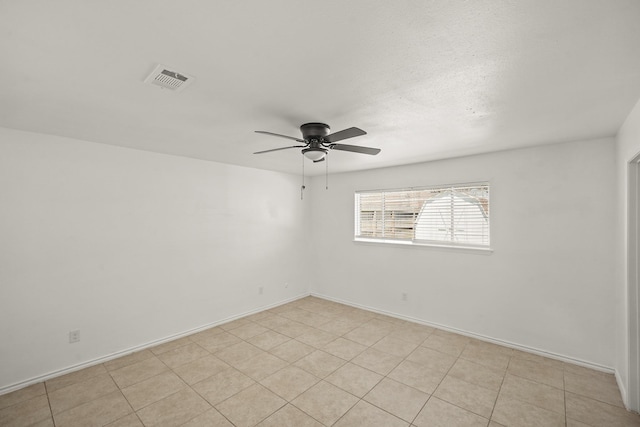 unfurnished room with baseboards, visible vents, and a ceiling fan