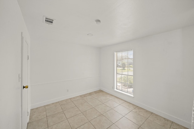 empty room with visible vents, baseboards, and light tile patterned floors