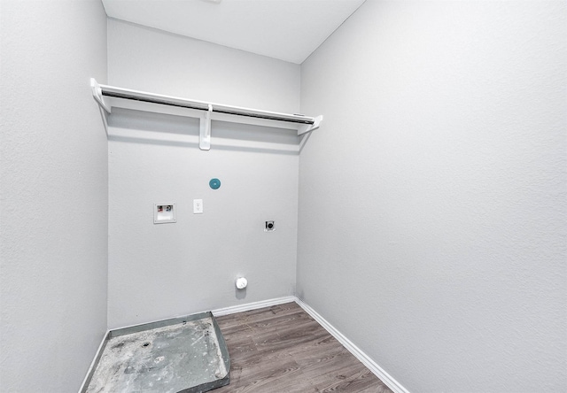 clothes washing area featuring washer hookup, electric dryer hookup, wood finished floors, laundry area, and baseboards