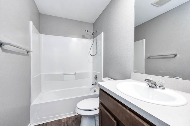 full bathroom featuring shower / bath combination, visible vents, toilet, wood finished floors, and vanity