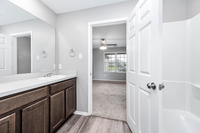 bathroom featuring ceiling fan, baseboards, wood finished floors, and vanity