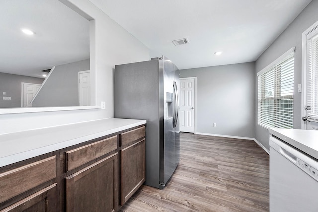 kitchen with light countertops, visible vents, dishwasher, and dark brown cabinets