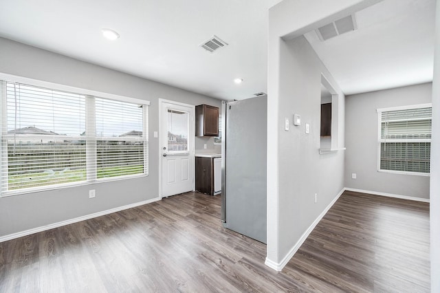 unfurnished room featuring baseboards, visible vents, and wood finished floors