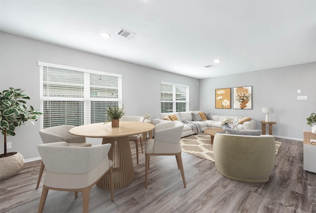 living area featuring baseboards, visible vents, wood finished floors, and recessed lighting