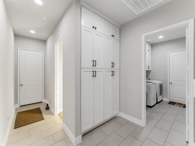 hall featuring washing machine and dryer, visible vents, baseboards, and recessed lighting