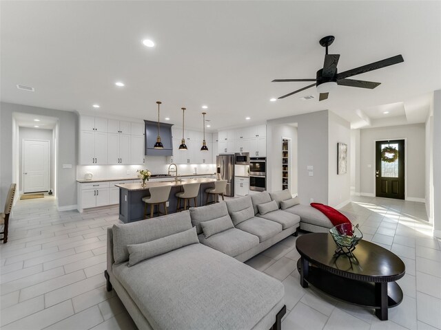 living room with light tile patterned floors, recessed lighting, visible vents, a ceiling fan, and baseboards