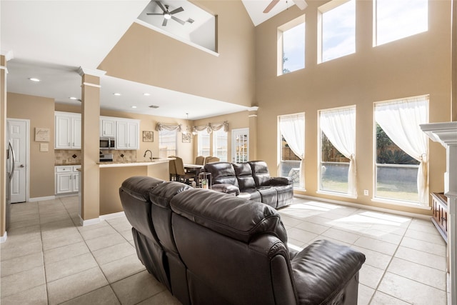 living area with a ceiling fan, recessed lighting, ornate columns, and light tile patterned floors