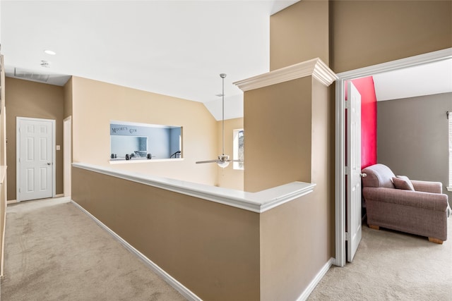 hallway featuring lofted ceiling, carpet, and baseboards