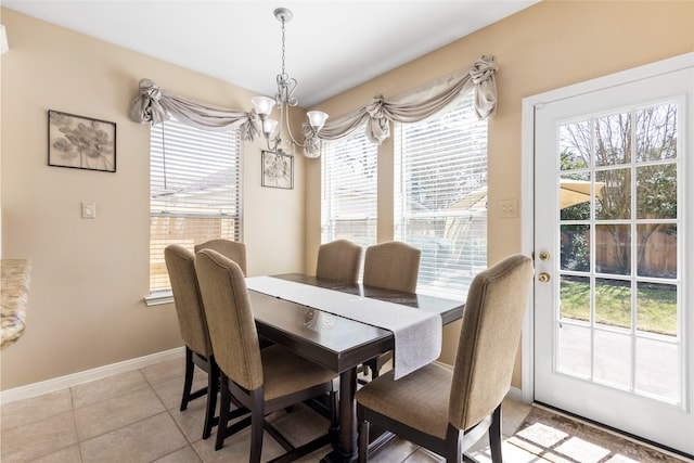 dining area with baseboards, light tile patterned flooring, and an inviting chandelier