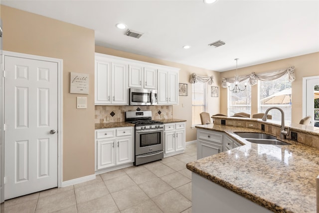 kitchen with a sink, visible vents, white cabinets, appliances with stainless steel finishes, and tasteful backsplash