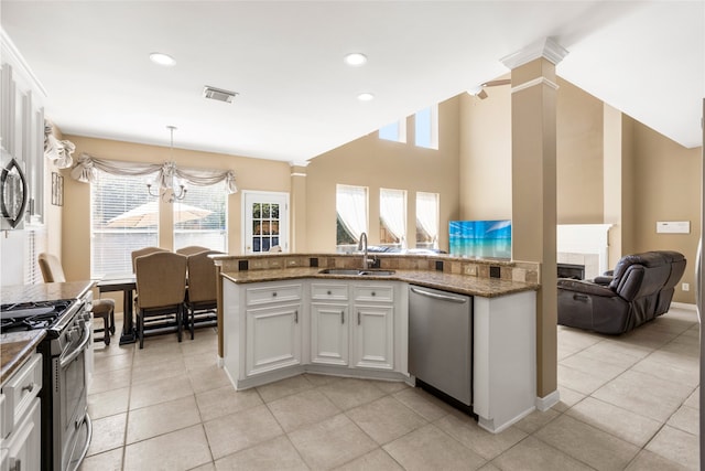 kitchen with stainless steel appliances, visible vents, open floor plan, a sink, and ornate columns