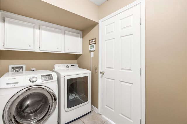 clothes washing area featuring cabinet space, separate washer and dryer, and light tile patterned flooring