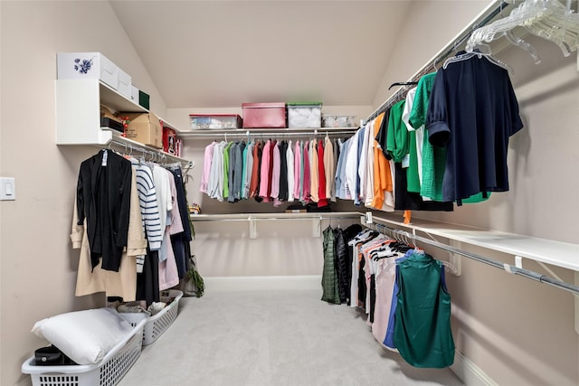 walk in closet featuring vaulted ceiling and carpet flooring