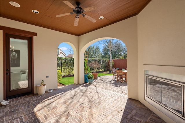 view of patio with ceiling fan, outdoor dining area, and fence