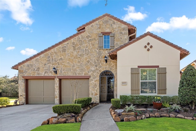 mediterranean / spanish-style home featuring a garage, stone siding, concrete driveway, and stucco siding