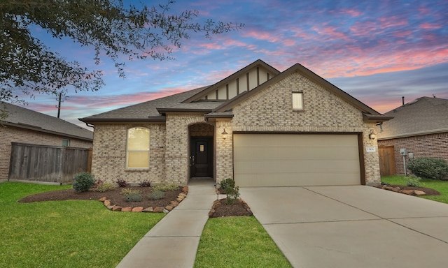 view of front of property with an attached garage, fence, concrete driveway, a yard, and roof with shingles