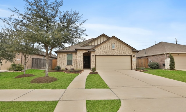 view of front facade with a front lawn, an attached garage, fence, and brick siding