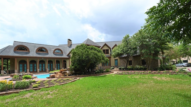 view of front facade featuring a front yard, an outdoor pool, and a chimney