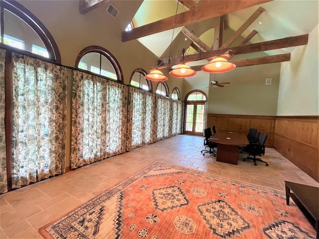 unfurnished office with stone tile flooring, visible vents, wainscoting, high vaulted ceiling, and beamed ceiling