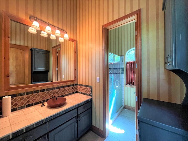 bathroom featuring baseboards, tile patterned floors, vanity, and wallpapered walls