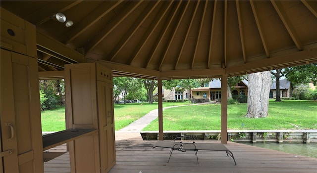 wooden deck with a lawn and a gazebo