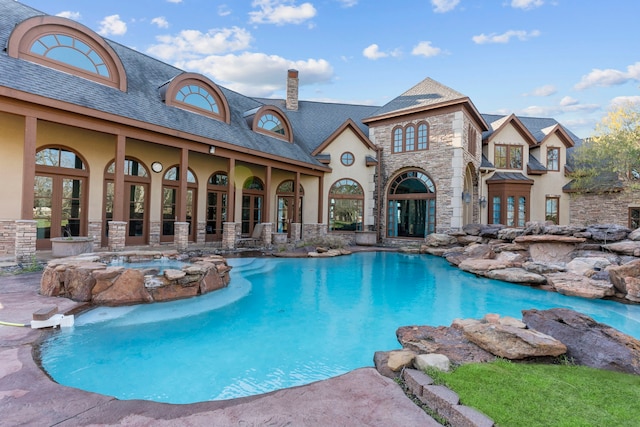 pool with an in ground hot tub and a patio