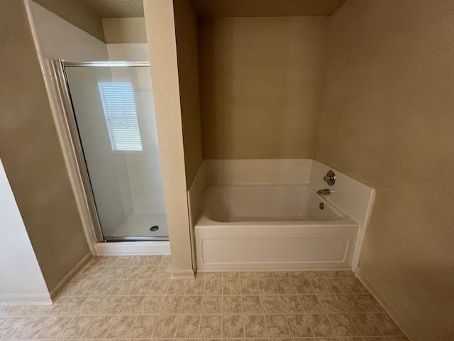 full bathroom with a shower stall, baseboards, and a bath