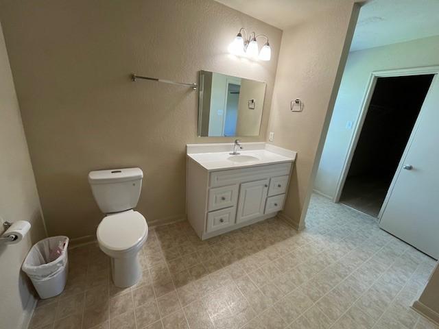 bathroom with vanity, toilet, and baseboards