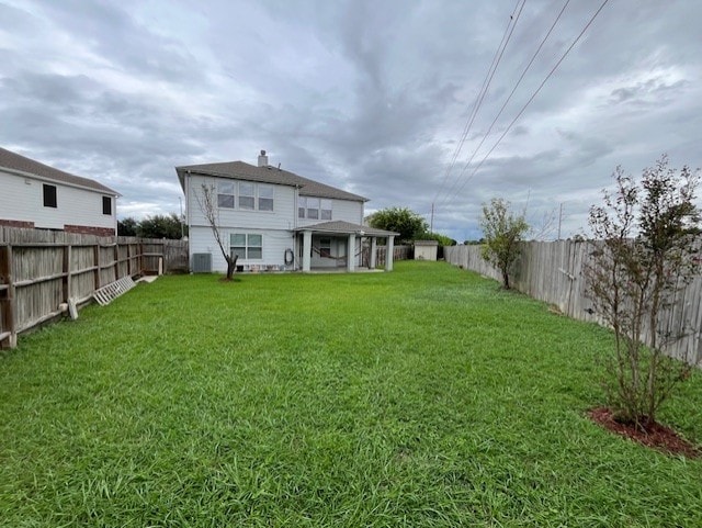 rear view of property featuring a fenced backyard, cooling unit, and a yard