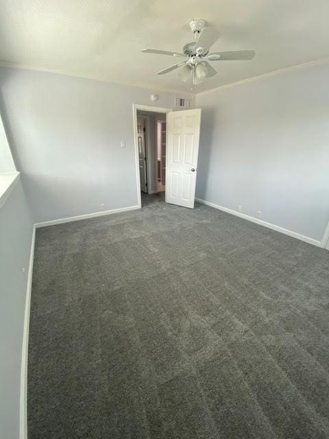 unfurnished bedroom with dark colored carpet, ceiling fan, and baseboards