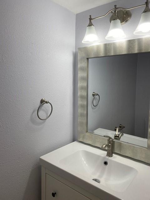 bathroom featuring a textured wall and vanity