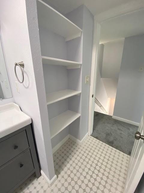 bathroom with vanity, baseboards, and tile patterned floors