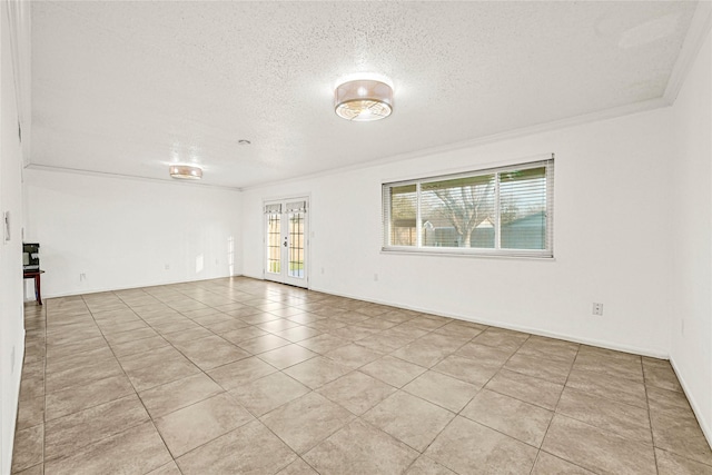 spare room with light tile patterned floors, ornamental molding, a textured ceiling, and french doors