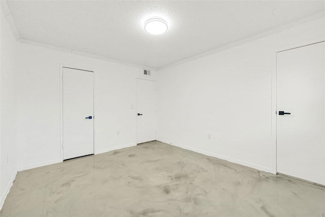 interior space featuring baseboards, concrete floors, visible vents, and crown molding