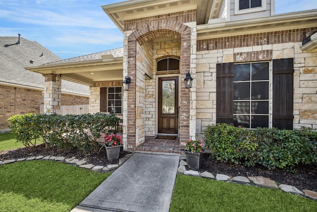 doorway to property with stone siding and brick siding