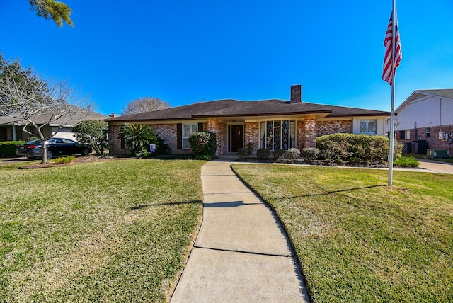 ranch-style house featuring brick siding, a chimney, and a front lawn