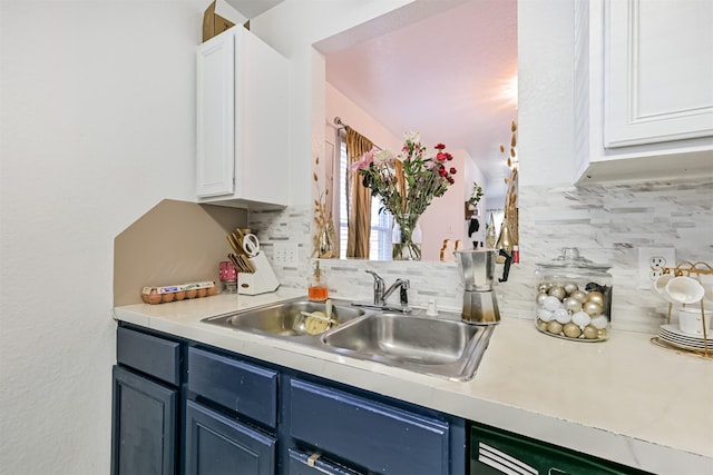 kitchen with light countertops, a sink, white cabinetry, and blue cabinets